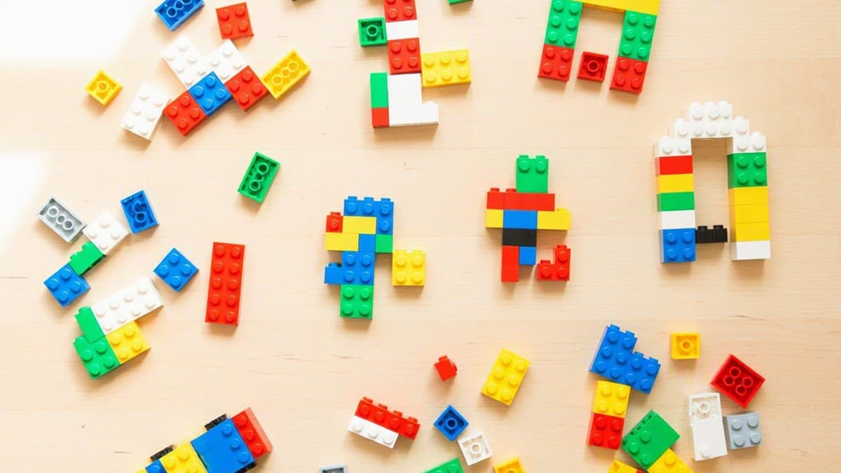 Assortment of colorful LEGO bricks and built creations on a wooden table