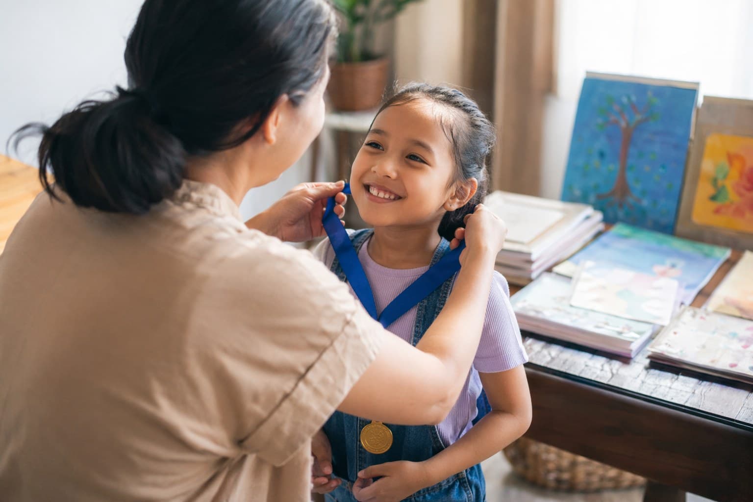 Small home homeschool graduation ceremony with a child receiving a homemade diploma from a parent